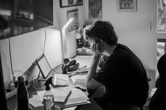 a person sitting at a desk with a laptop